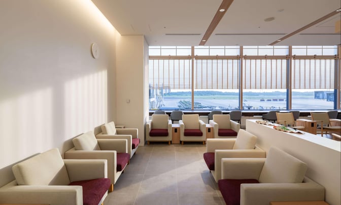 The seating area in the IASS Superior Lounge at Narita International Airport offers comfortable chairs with views of the runway.