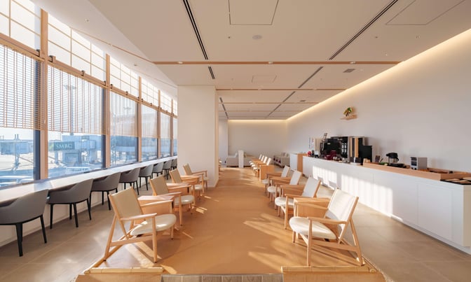 The IASS Superior Lounge at Narita International Airport features a seating area with individual chairs and a counter with runway views.