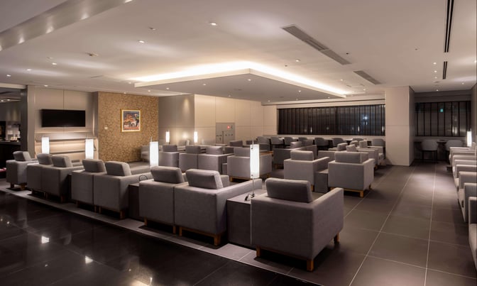 The IASS Superior Lounge at Narita International Airport features a spacious seating area with individual armchairs and a television.