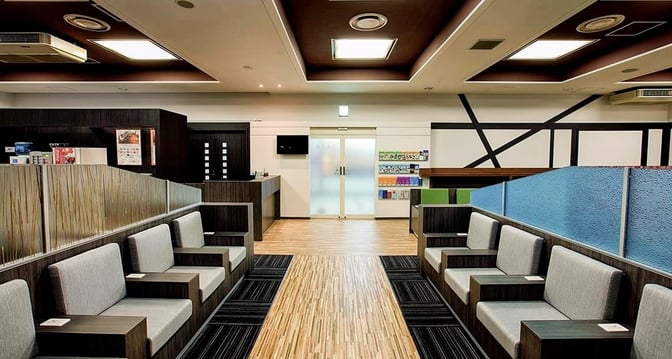 The IASS Executive Lounge 2 at Narita International Airport features booth seating with privacy dividers and a central walkway.