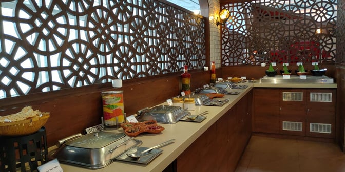The buffet area at the Travel Club Annex in Kolkata Airport offers a variety of self-serve hot and cold dishes.
