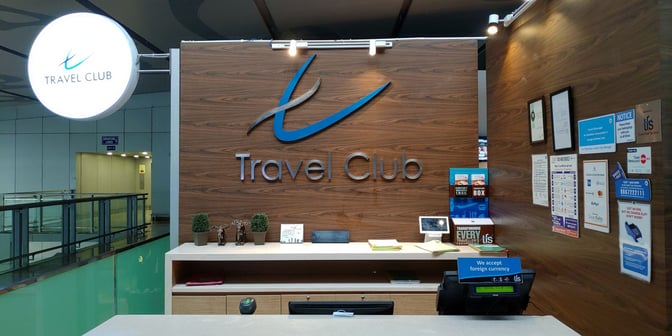 The Travel Club lounge entrance at Kolkata Airport features a reception desk with signage and information displays for travelers.