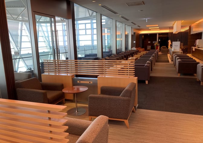 The North Lounge at New Chitose Airport features individual seating areas with armchairs and tables, offering views of the terminal.