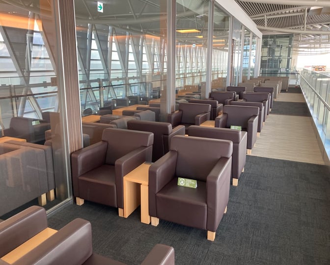 The North Lounge at New Chitose Airport features rows of armchairs with side tables, offering a comfortable seating area for travelers.