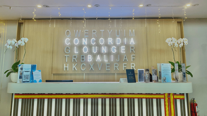 The reception desk at Concordia Lounge, Ngurah Rai International Airport, features informational brochures and signage welcoming members.
