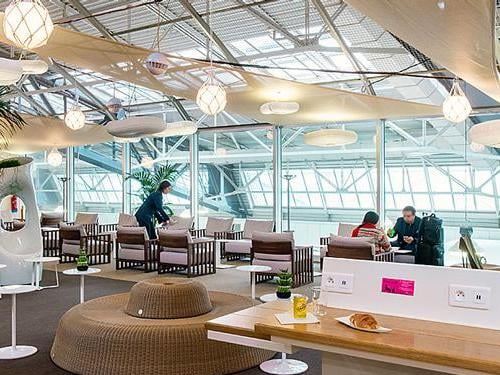 The Canopy Lounge at Nice International Airport features a seating area with tables, chairs, and charging stations for travelers.