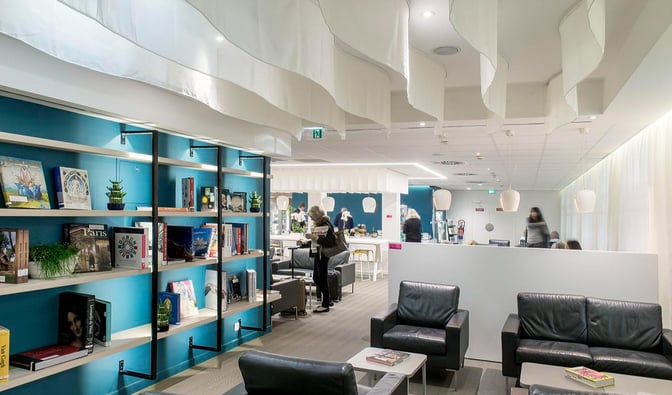 The Library Lounge at Nice International Airport features a seating area with bookshelves and comfortable chairs for travelers.