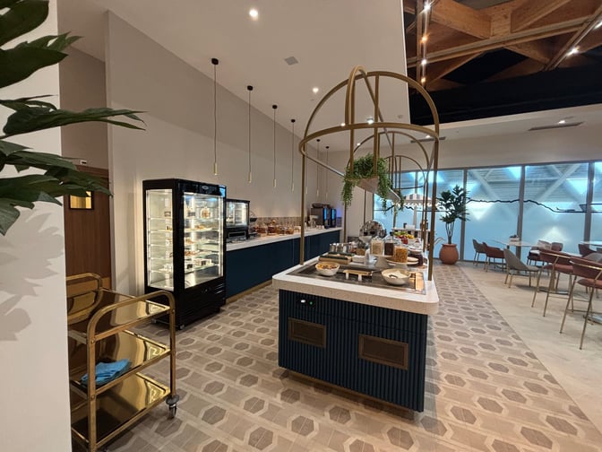 The Levity Lounge at Nice International Airport features a self-serve food station with various breakfast options and adjacent seating areas.