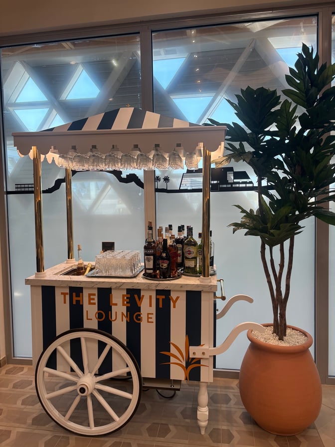 The Levity Lounge at Nice International Airport features a mobile bar cart offering a selection of spirits and glassware for guests.