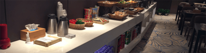 The China Eastern Lounge at Ningbo Lishe International Airport features a self-serve food station with snacks, beverages, and dining tables nearby.
