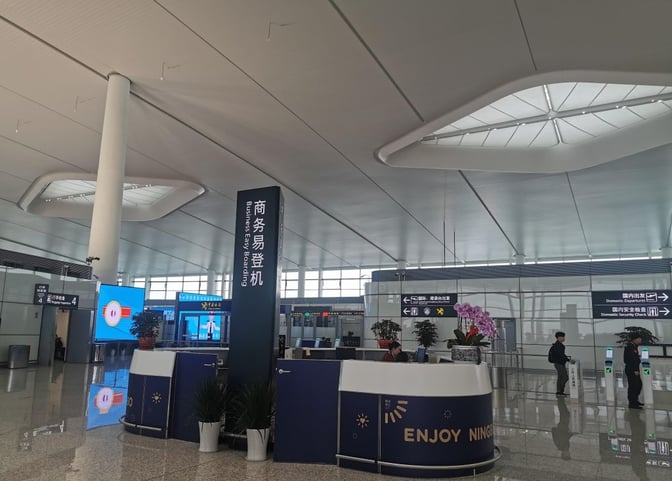 The Business Easy Boarding area at Ningbo Lishe International Airport features a reception desk and directional signage for domestic departures.