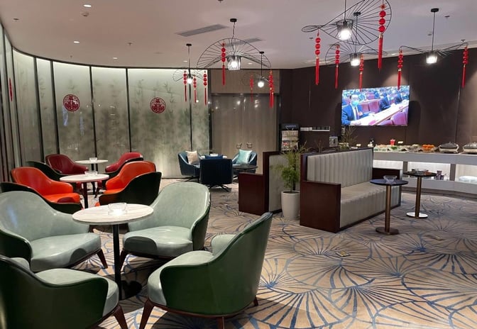 The First Class Lounge at Ningbo Lishe International Airport features varied seating options, a television, and a self-serve food area.