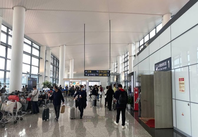 The entrance to the First Class Lounge at Ningbo Lishe International Airport is located near gate signs and passenger seating areas.