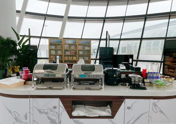 The YONGYI VIP Room at Ningbo Lishe International Airport features a self-serve food station with chafing dishes and beverage options.