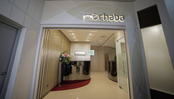 The entrance to the marhaba Lounge at Ninoy Aquino International Airport features a reception desk and welcoming floral arrangement.