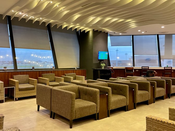 The PAGSS Lounge at Ninoy Aquino International Airport features comfortable seating with views of the tarmac and a flight information screen.