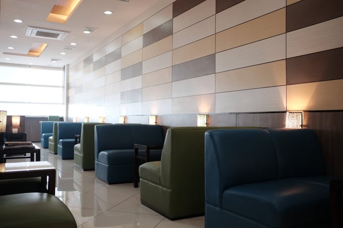 Booth seating in the Marhaba Lounge at Ninoy Aquino International Airport offers semi-private spaces with individual tables and wall lighting.