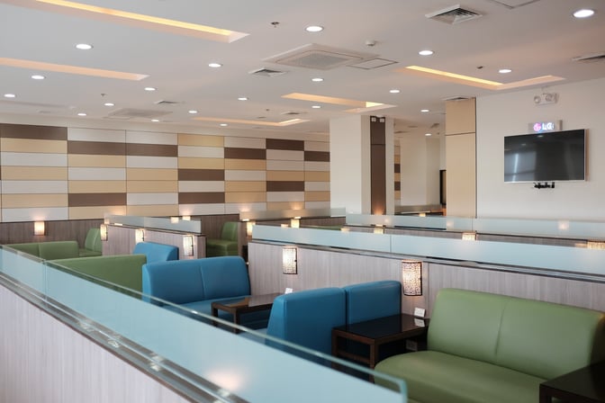 The seating area in Marhaba Lounge at Ninoy Aquino International Airport features semi-private booths with cushioned chairs and individual tables.