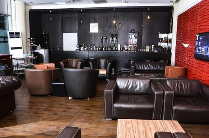 The 9TYSIX VIP Lounge at Nnamdi Azikiwe International Airport features a bar area with various seating options for guests.