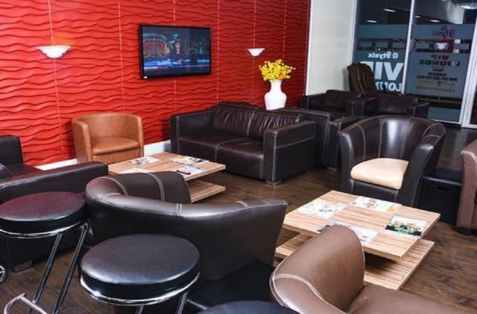 The 9TYSIX VIP Lounge at Nnamdi Azikiwe International Airport features comfortable seating with tables and a wall-mounted television.