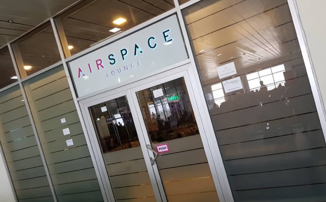 The entrance to the Airspace Lounge at Nnamdi Azikiwe International Airport features glass doors with signage indicating entry.