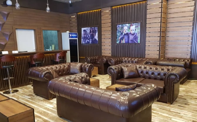 The Airspace Lounge at Nnamdi Azikiwe International Airport features leather seating and a bar area with high stools for travelers.