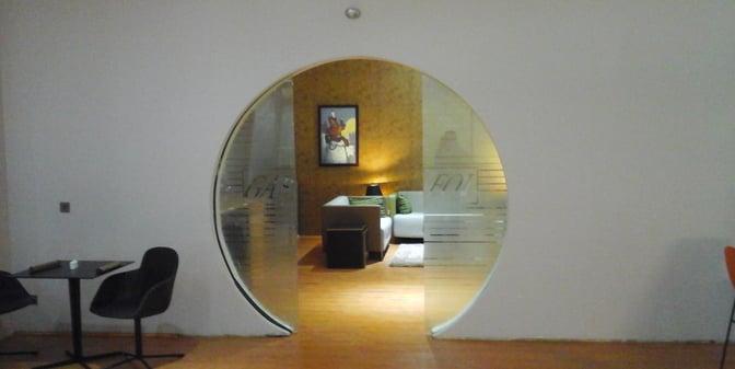 The entrance to the Gabfol Lounge at Nnamdi Azikiwe International Airport features a circular glass door leading to a seating area.