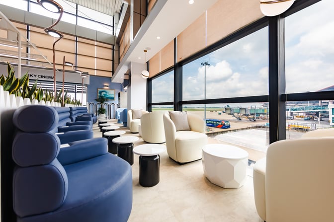 The ASG Sky Lounge at Noi Bai International Airport features comfortable seating with views of the airport tarmac through large windows.