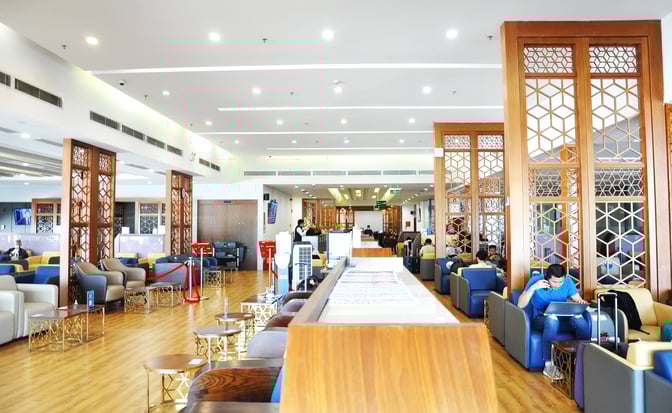 The Vietnam Airlines Lotus Lounge at Noi Bai International Airport features spacious seating areas with individual chairs and small tables for travelers.