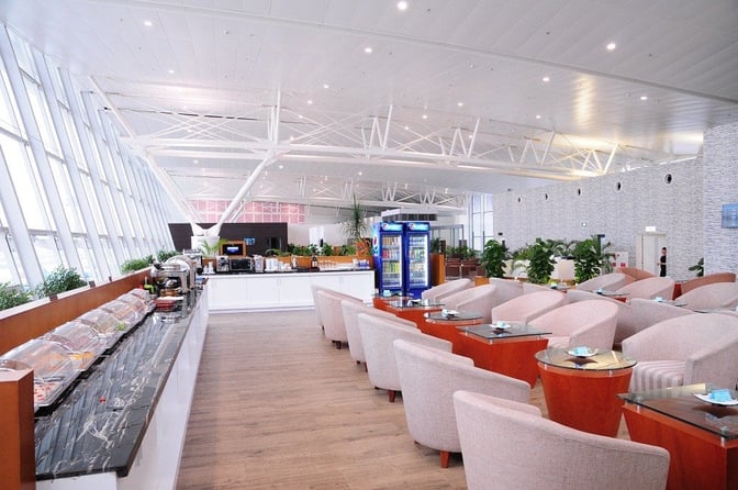 The ACV Business Lounge at Noi Bai International Airport features a self-serve food area and comfortable seating with tables.