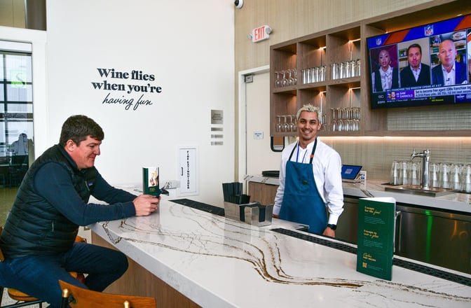 The bar at Escape Lounge in Northwest Arkansas Regional Airport offers counter seating with a selection of beverages and a TV.