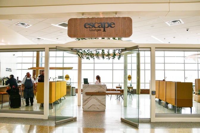The entrance to the Escape Lounge at Northwest Arkansas Regional Airport features a reception desk and visible seating areas inside.