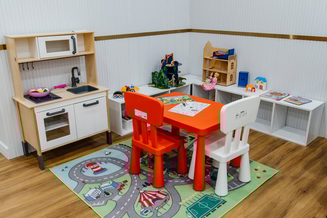 The children's play area at Sapar Lounge features a play kitchen, small table with chairs, and various toys for entertainment.