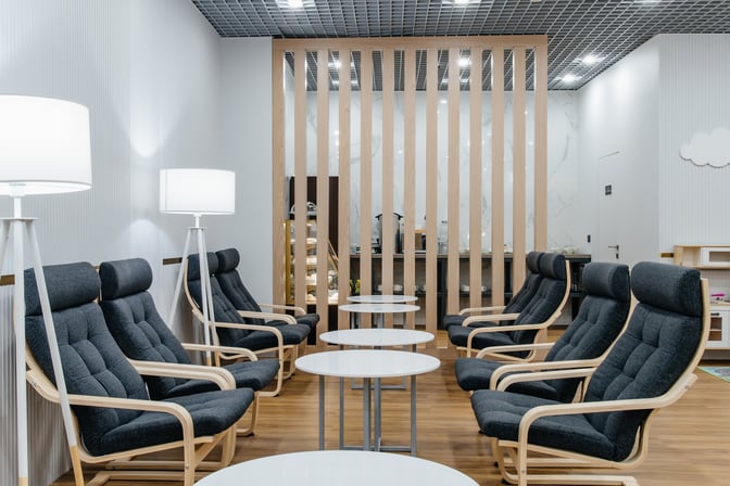 The seating area at Sapar Lounge features comfortable chairs and small tables, providing a relaxing space for travelers.