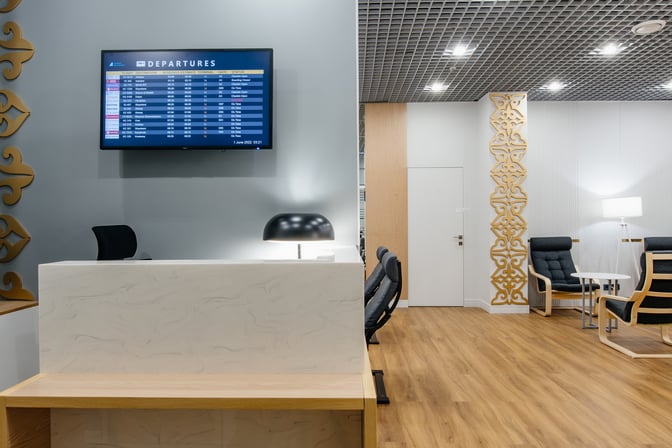 The Sapar Lounge at Nursultan Nazarbayev International Airport features a seating area with armchairs and a departure information screen.
