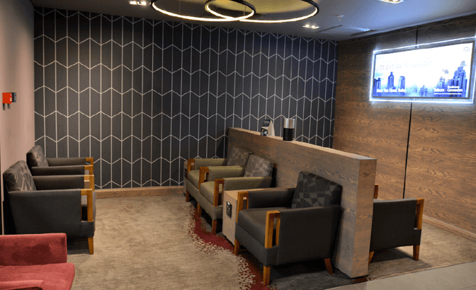The seating area in Bidvest Premier Lounge at O. R. Tambo International Airport features armchairs and a partition for semi-private relaxation.