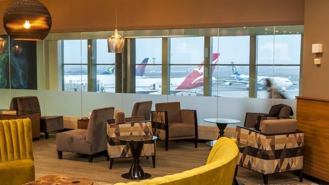 Seating area in the Aspire Lounge at O. R. Tambo International Airport offers comfortable chairs with views of the runway.