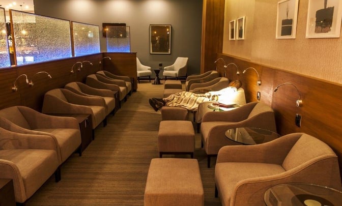 The Aspire Lounge at O. R. Tambo International Airport features a seating area with individual chairs, footrests, and personal reading lights.