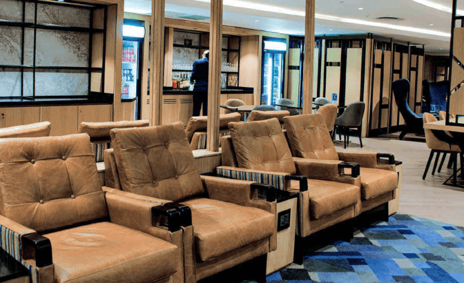 The Bidvest Premier Lounge at O. R. Tambo International Airport features comfortable seating and a bar area with beverage service.