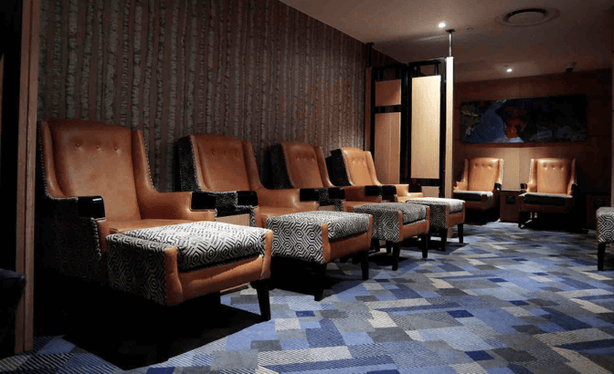 The Bidvest Premier Lounge at O. R. Tambo International Airport features a seating area with comfortable armchairs and footrests for relaxation.