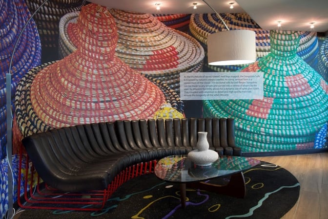 The Shongololo Lounge at O. R. Tambo International Airport features a curved seating area with a decorative wall and a central table.