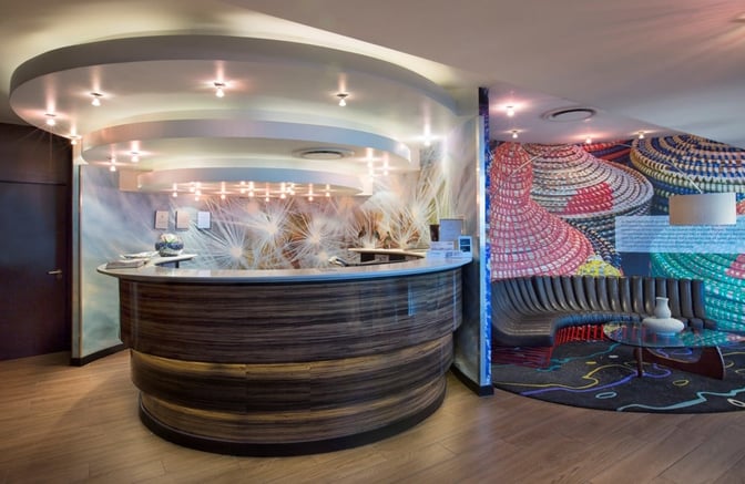 The Shongololo Lounge at O. R. Tambo International Airport features a reception desk and a curved seating area with a decorative wall.