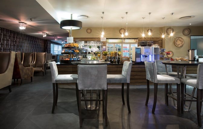 The Shongololo Lounge at O. R. Tambo International Airport features a self-serve food and beverage area with seating options.