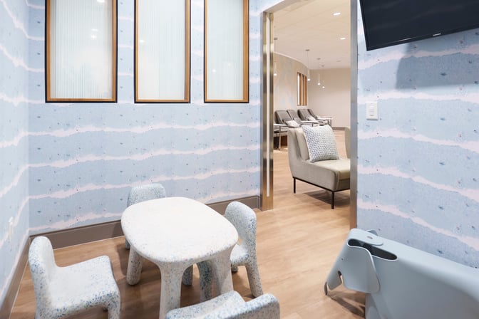 A children's play area in Club MCO Airside 1 features small tables and chairs adjacent to a seating lounge.