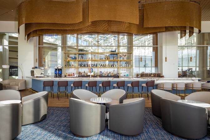 The Plaza Premium Lounge at Orlando International Airport features a bar with a variety of spirits and seating options.