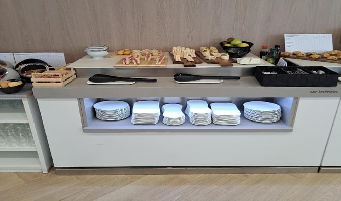 The Mestral VIP Lounge at Palma de Mallorca Airport features a self-serve food station with a variety of snacks and plates.