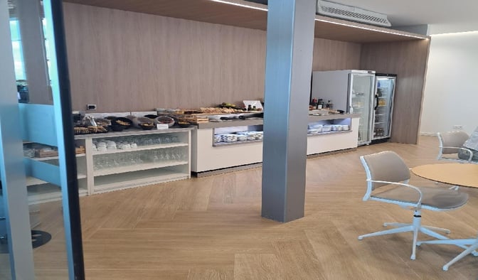 The Mestral VIP Lounge at Palma de Mallorca Airport features a self-serve food area with snacks, beverages, and seating nearby.