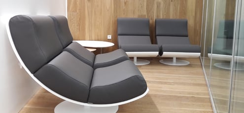 Seating area in the Sala VIP Mediterraneo at Palma de Mallorca Airport features modern chairs and a small table for passenger comfort.