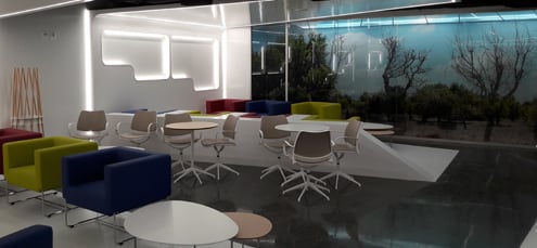 The seating area in the Sala VIP Mediterraneo at Palma de Mallorca Airport features tables and chairs with a nature-themed backdrop.