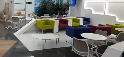 The seating area in Sala VIP Mediterraneo at Palma de Mallorca Airport features various chairs and tables for passenger relaxation.